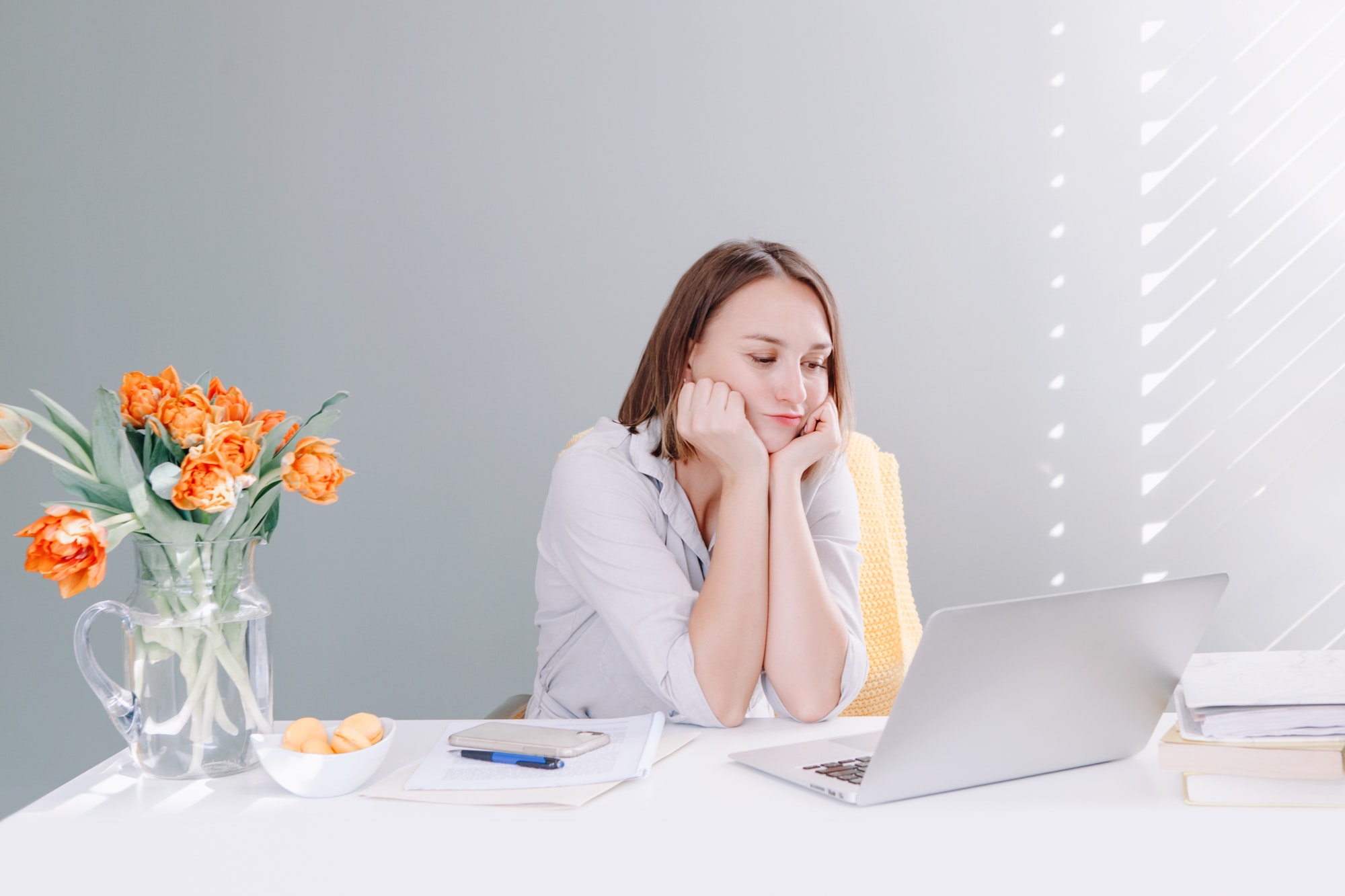 Puzzled overwhelmed business woman working on laptop from home office. Tired bored woman.