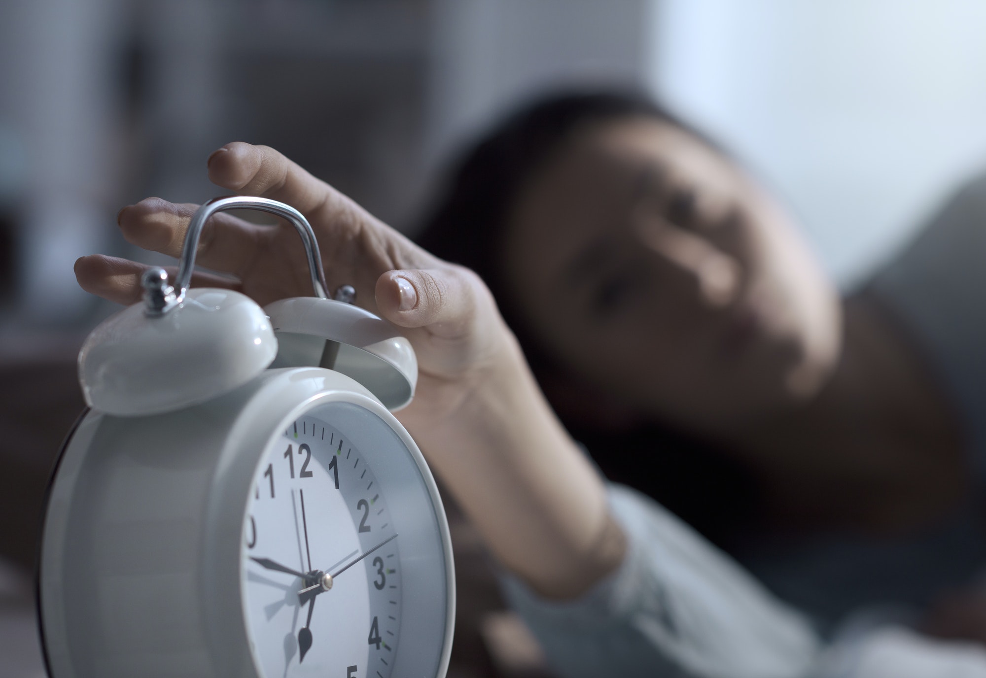 Woman waking up in the morning and alarm clock
