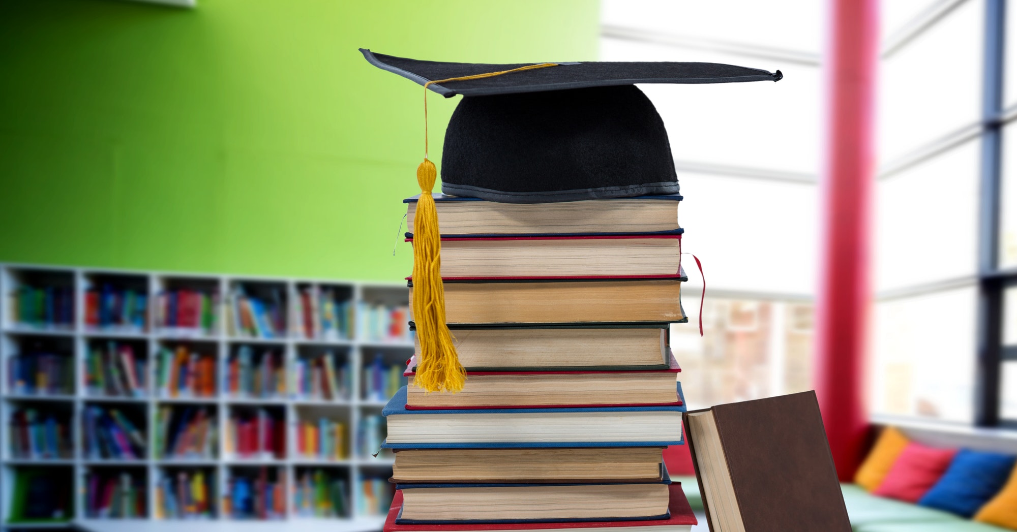 Books and graduation hat in education library