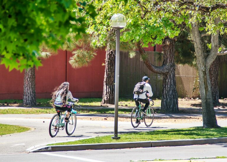College students riding bicycles through campus on a sunny spring day