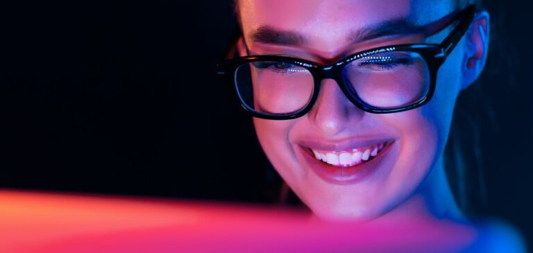 Happy girl looking at laptop screen at night