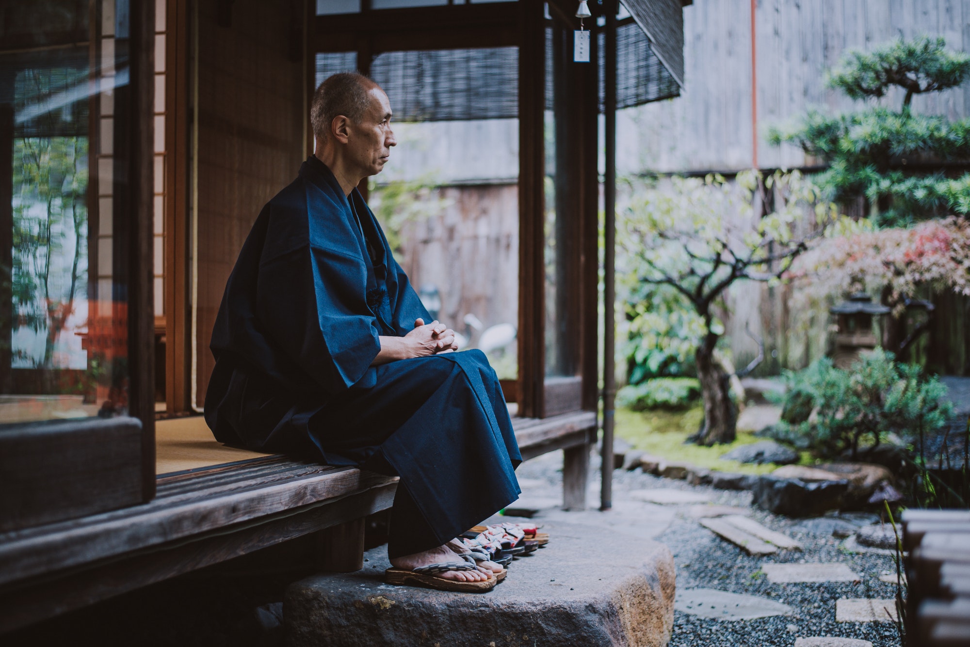 Japanese man meditating in his garden