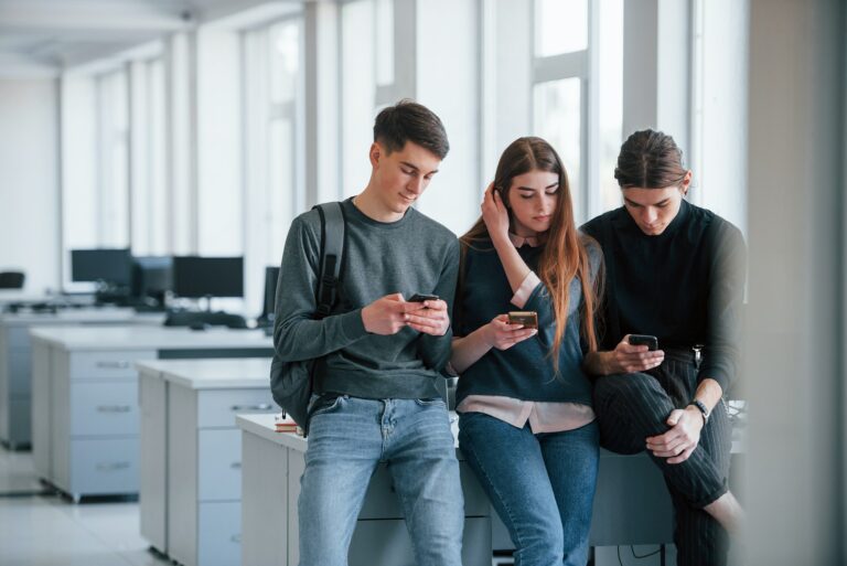 Internet addiction. Group of young people in casual clothes have a rest in the modern office