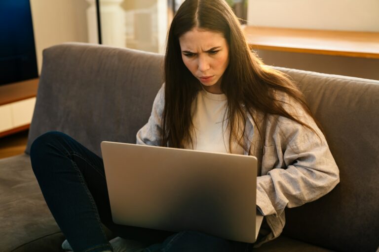 Unhappy stressed woman looking at laptop computer