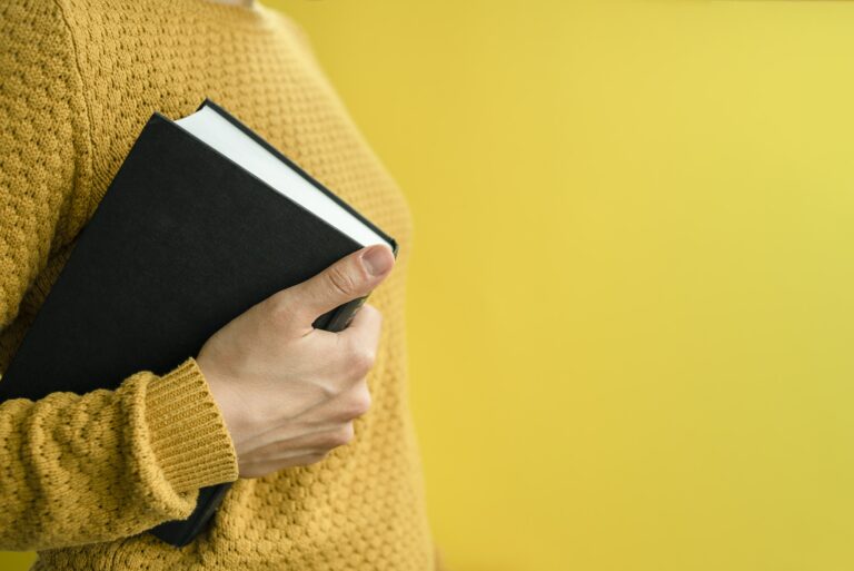 Woman student with books on yellow