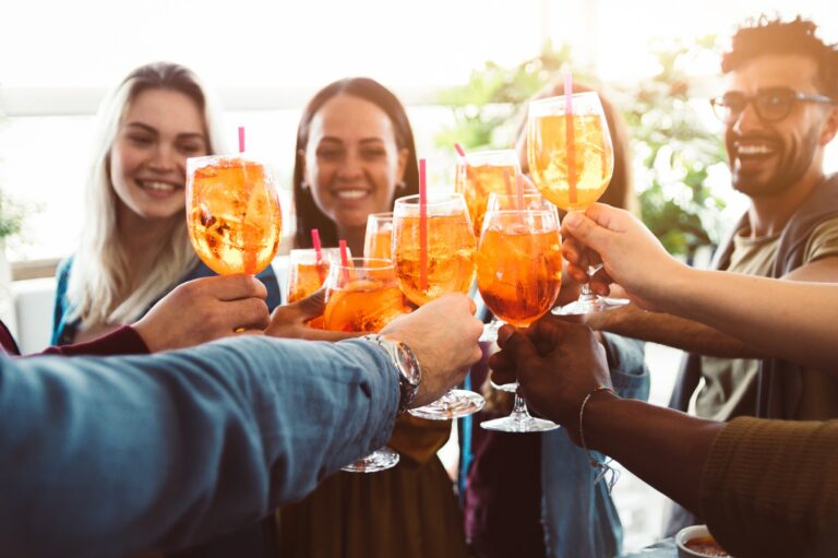 Group of happy friends drinking and toasting friends at a bar restaurant