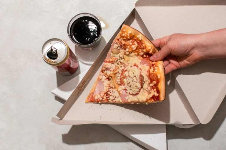 Slice of pizza in a box with Coca-Cola. Home food delivery. Junk food