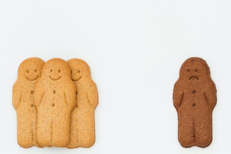white gingerbread men and a sad black gingerbread man in kids racism and racial segregation concept