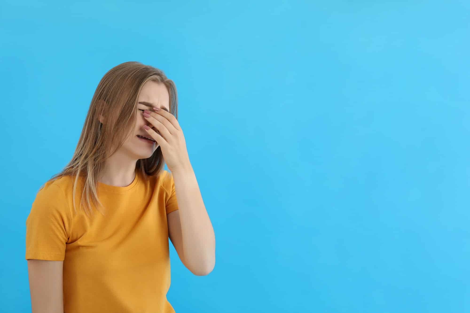 crying girl in t shirt on blue background