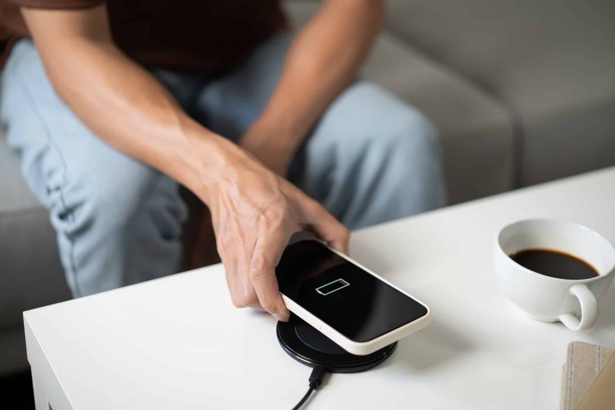 man hands charging mobile phone battery with low battery plugging a charger in a smart phone