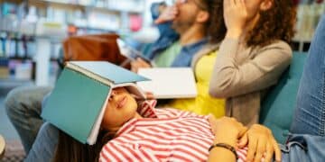 College, study, university and education concept. Group of tired students learning in library