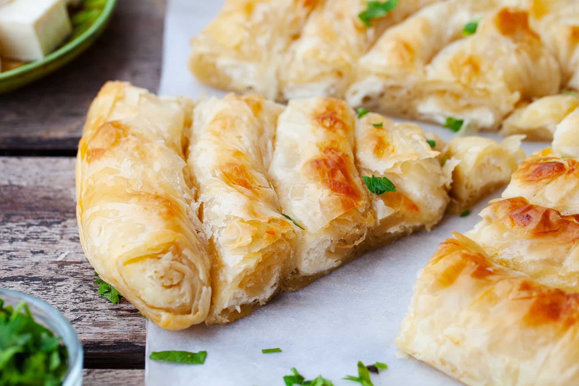 Traditional Feta Cheese Phyllo Pastry Pie, Banitsa. Wooden Background. Close up.