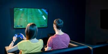 Couple playing football game with gaming console