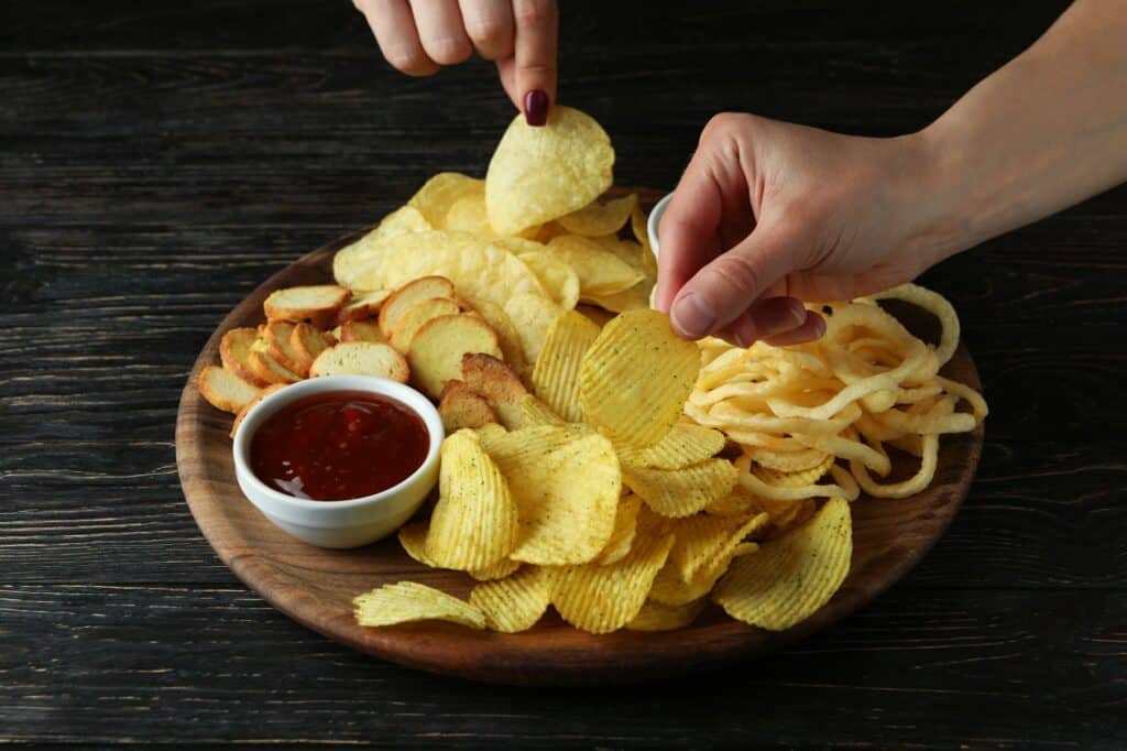 female hands hold chips over the tray with chips close up