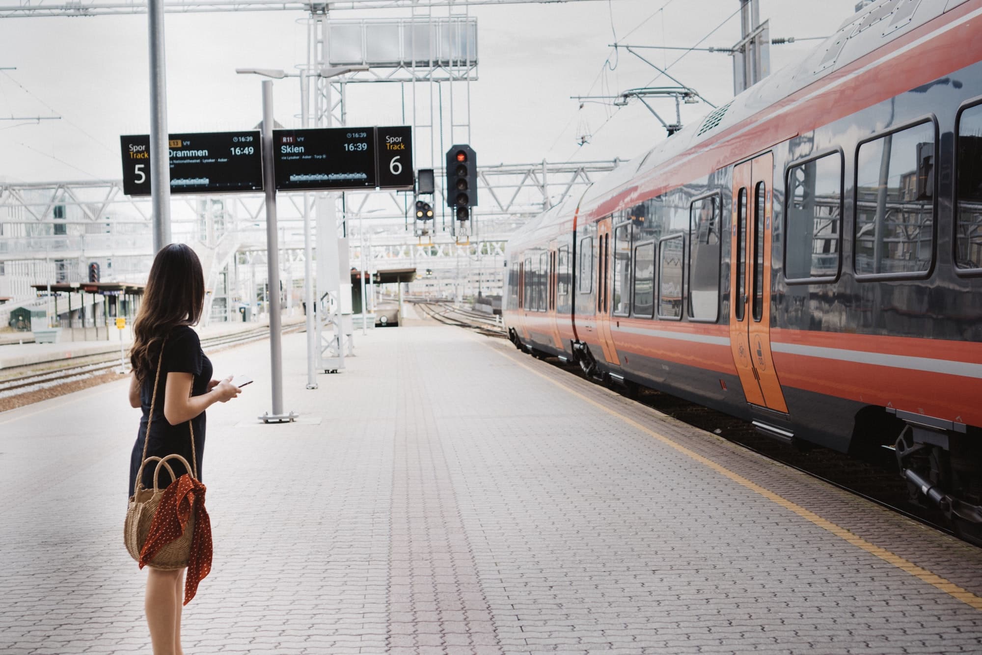 woman waiting at train station platform for train to arrive