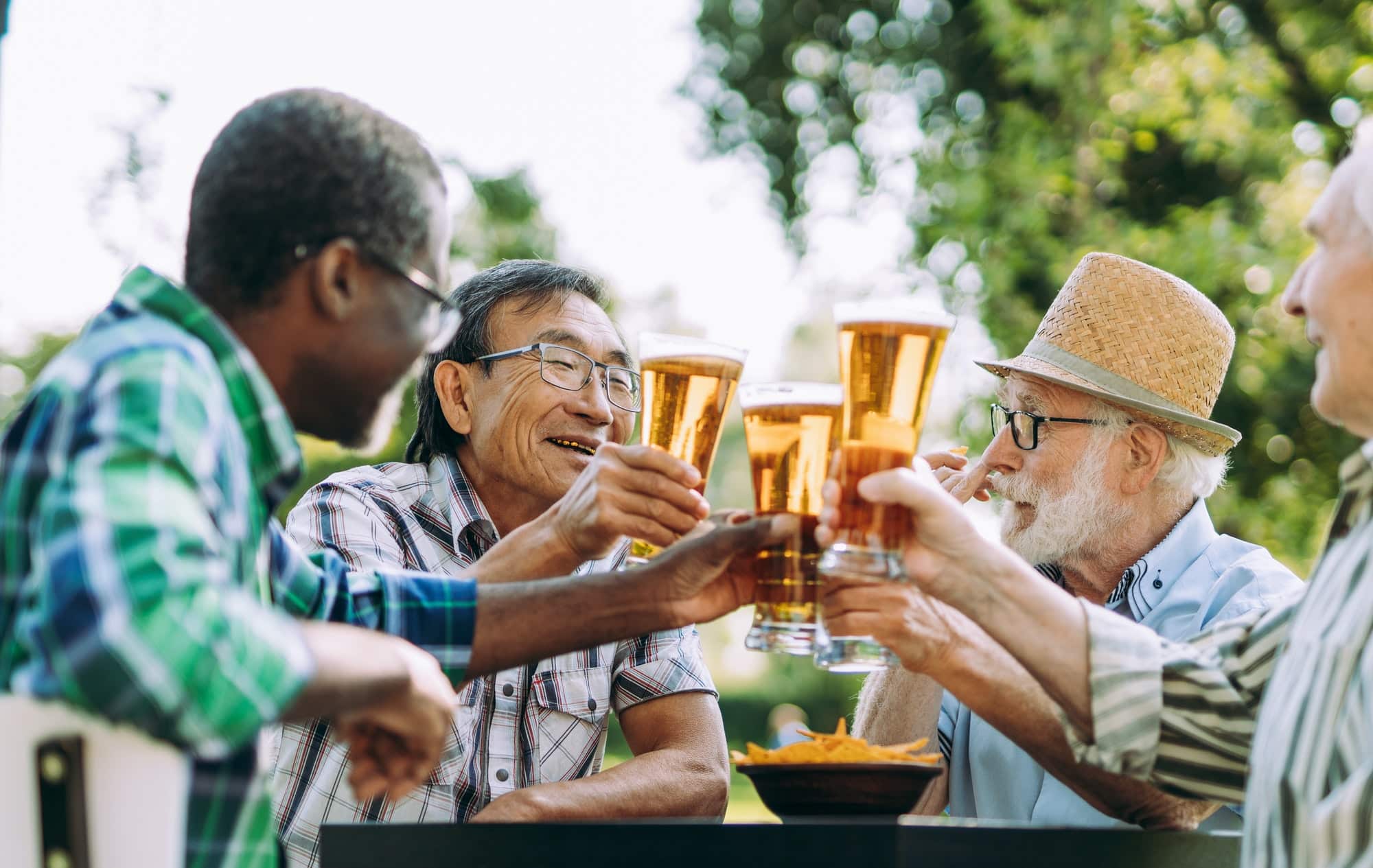 group of senior friends drinking a beer at the park