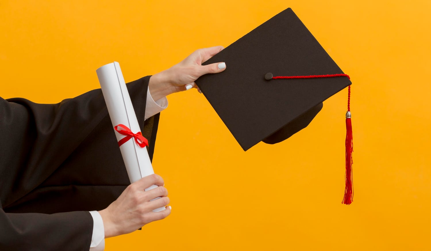 close up hands holding diploma cap