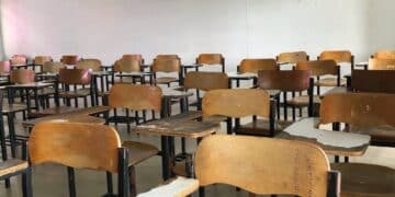 Wooden chairs in classroom interior empty wall background