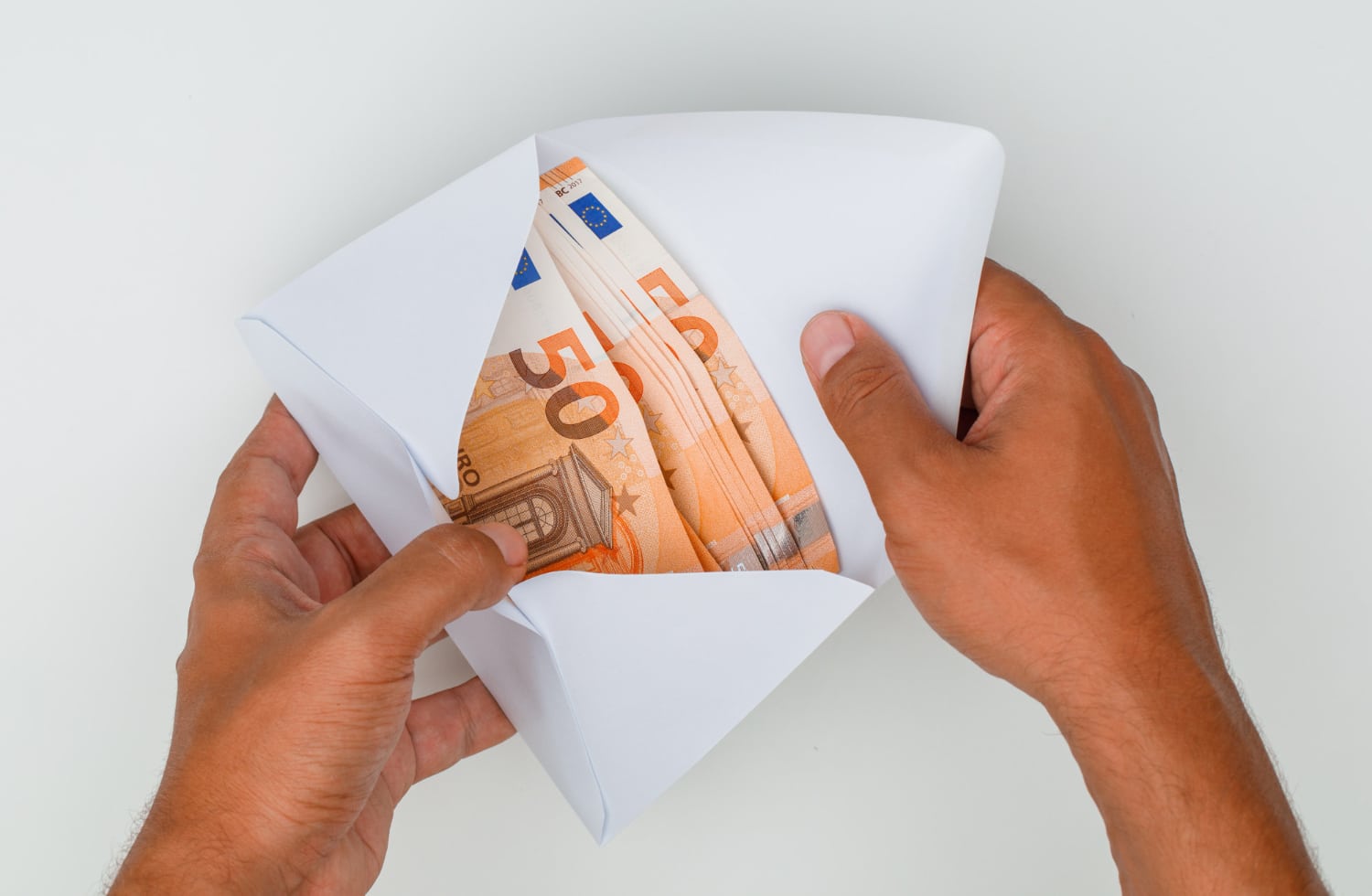 hands opening envelope full banknotes