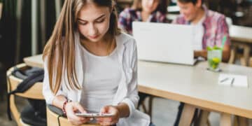 girl using tablet cafe with classmates