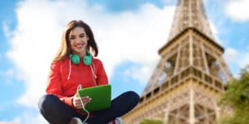 technology travel tourism music people concept smiling young woman teenage girl with tablet pc computer headphones paris eiffel tower background