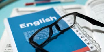 english book with glasses table