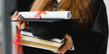 female student holding diploma books