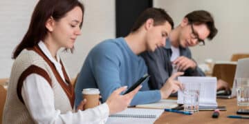 classmates using smartphone during group study