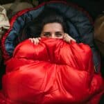 a young woman in a comfortable sleeping bag in a tent top view a tourist in a sleeping bag