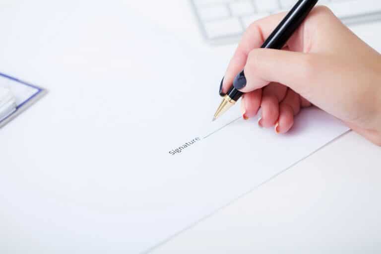 business woman signing a contract above signature line