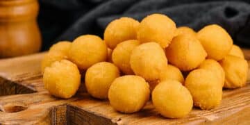 tasty cheese balls on a wooden board
