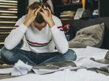 stressed teen sitting in his bedroom